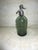 The vintage 1930's green Argentina handmade glass and metal 12" tall soda/seltzer bottle is a rare and unique collectible...