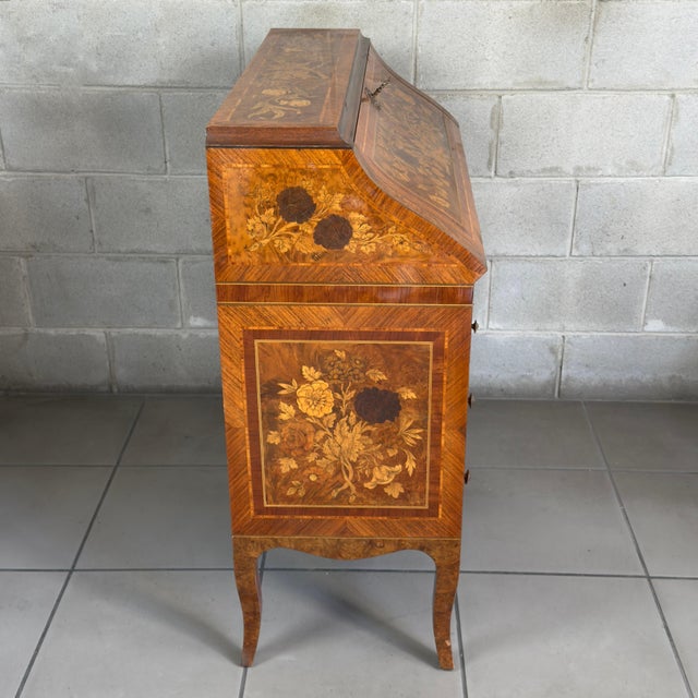 An elegant secretary desk with a drop-down top, attributed to an Italian workshop from the early 20th century and inspired...