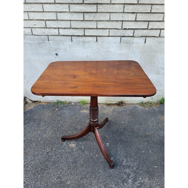 We are pleased to offer this elegant 19th Century American Federal Walnut Tilt-Top Table. Crafted from rich Walnut wood,...