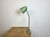 Green industrial adjustable workshop table lamp was made in former Czechoslovakia during the 1960s. It features an iron...