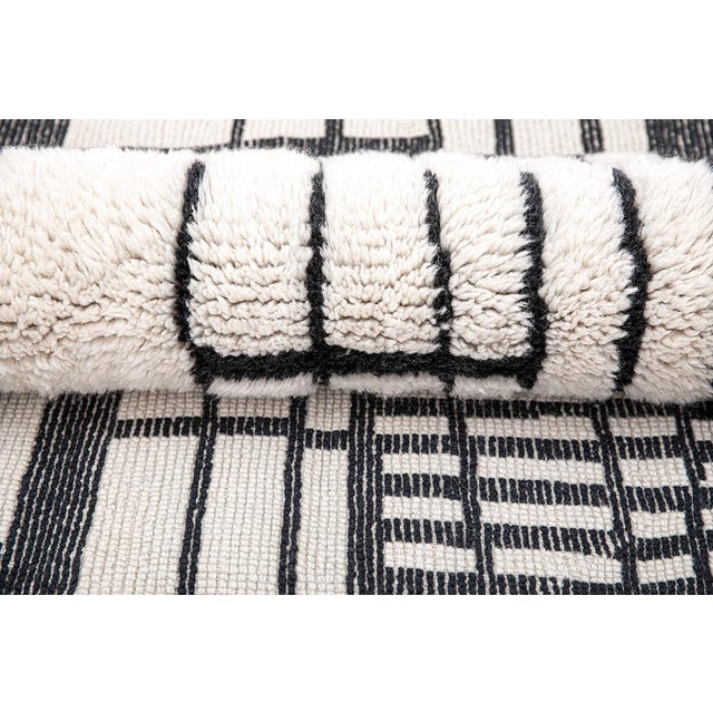 Clean lines, sharp contrast, effortless sophistication. This hand-knotted Moroccan rug features a striking linear...