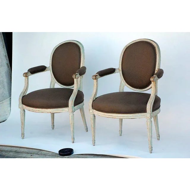 Pair of period Louis XVI whitewashed "medaillon" armchairs. Restored and reupholstered in dark grey linen.