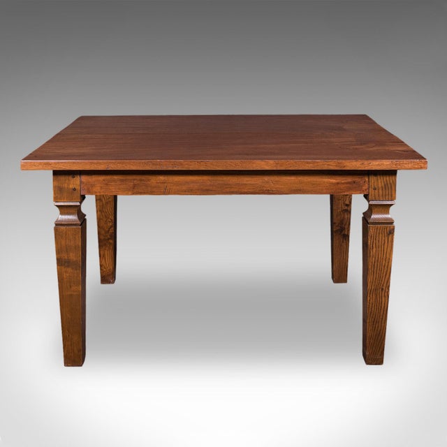 This is an antique kitchen diner table. An English, solid walnut four seat dining table, dating to the Edwardian period,...