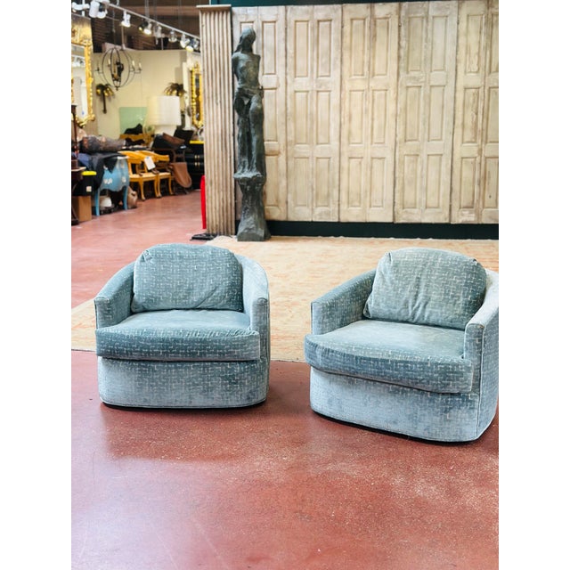 A stylish pair of vintage barrel-back lounge chairs newly upholstered in luxurious designer velvet. Featuring gracefully...