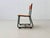 Small children's chair with a blue-green lacquered tubular steel frame in a sled shape and a solid wood seat and backrest...