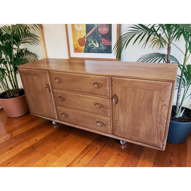A beautifully crafted mid-century ercol windsor sideboard, designed by lucian ercolani, showcasing the very best of...