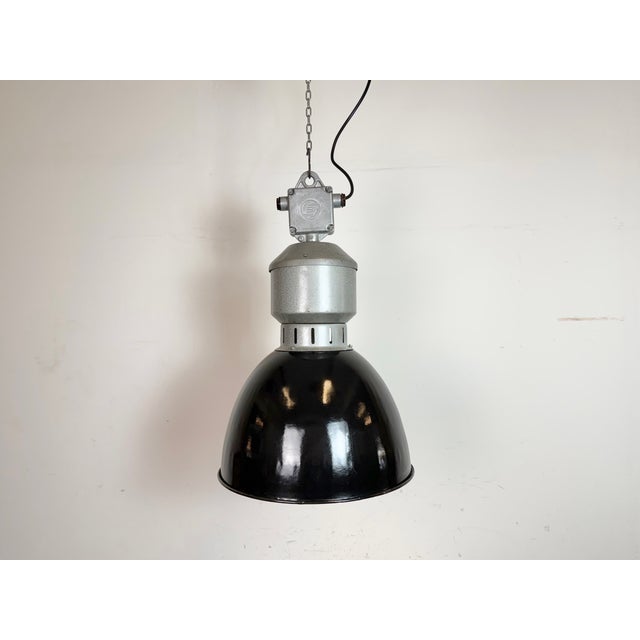 Industrial black enamel pendant light made by Elektrosvit in former Czechoslovakia during the 1960s. White enamel inside...