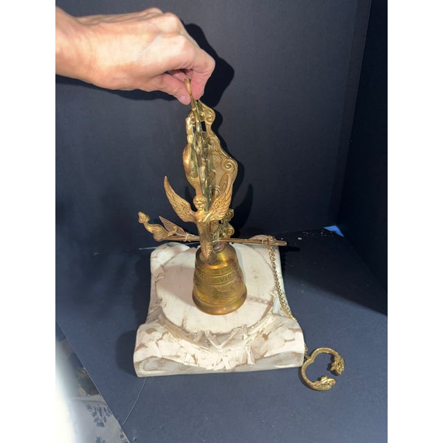 Antique brass wall mounted pull bell used as a monastery bell.the is a striking angel on the front of the bracket. It has...