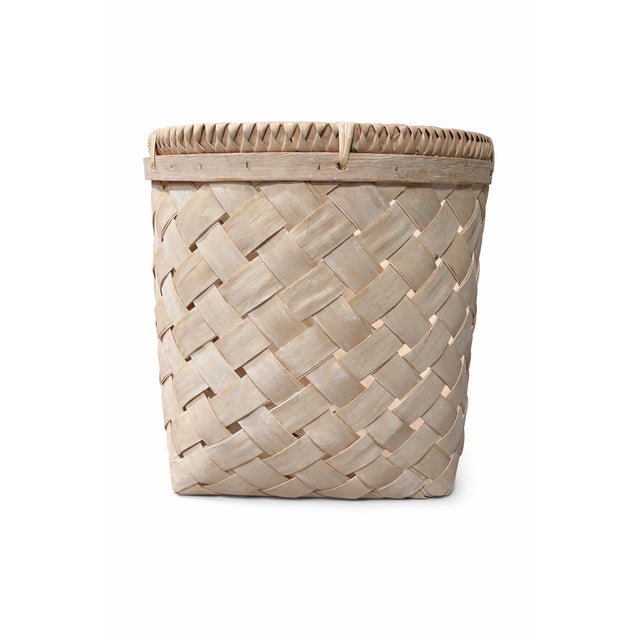A substantial vintage handwoven storage basket dating to the late 1980s to early 1990s, featuring a warm natural reed...