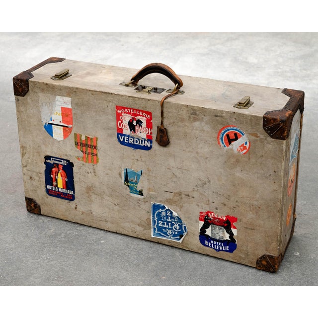 A rare Hermès suitcase dating from the 1920s, marked by travel and covered in numerous stickers from period hotels and...