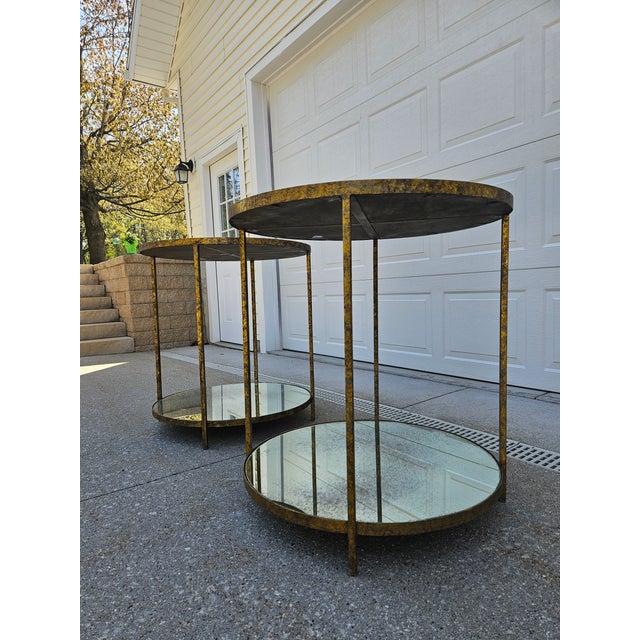 A pair of two-tiered tall Jonathan round side tables from Oly Studio. This pair of tables features an antiqued gold finish...
