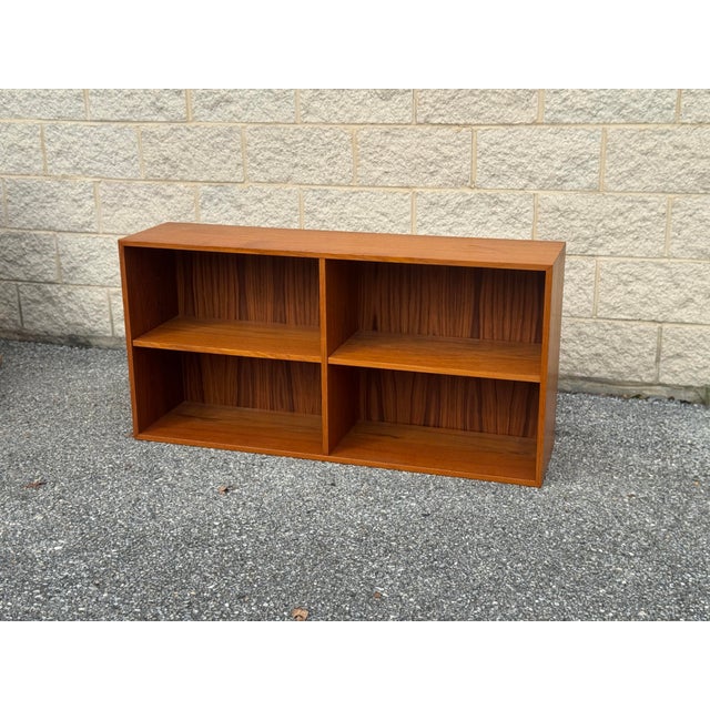 Vintage Danish Modern low bookcase crafted in teak, circa 1960s–1970s. Clean rectangular form with a central divider and...