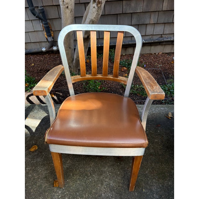 A beautifully composed vintage Shaw Walker armchair featuring a striking mix of brushed steel, warm-toned wood, and...