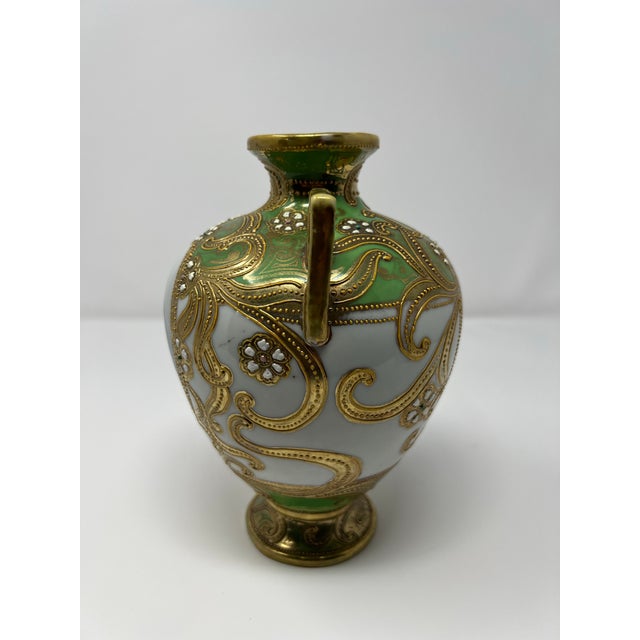 An elegant antique Japanese Nippon porcelain cabinet vase dating to the early 20th century (circa 1905–1915). The twin-...