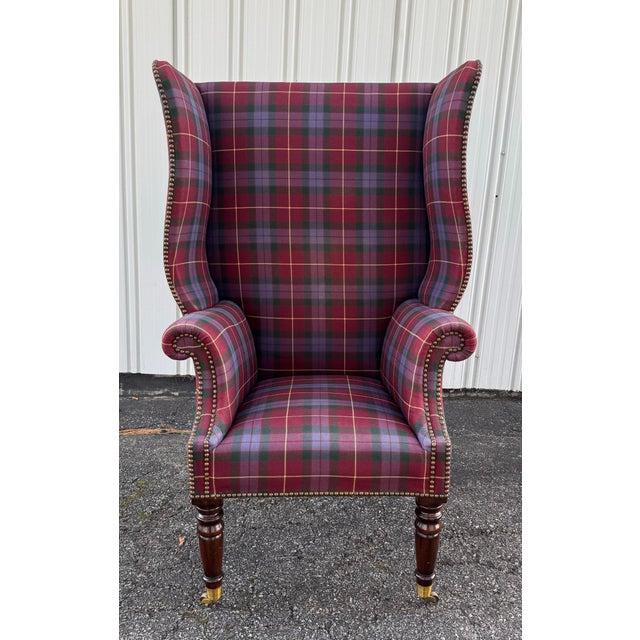 Vintage English Wingback Chair in Ralph Lauren wool plaid tartan on turned mahogany legs with brass casters. There is no...