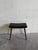 Vintage Danish modern ottoman crafted in teak with newly upholstered black vinyl seat. Features clean Scandinavian lines,...