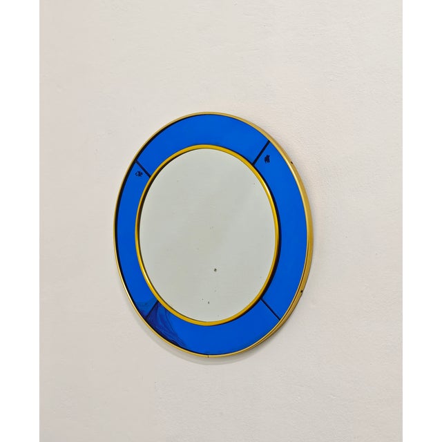 Circular wall mirror in blue glass and brass, produced by the Italian company Cristal Art of Turin. Cristal Art, a leading...