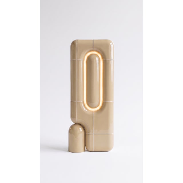 The vertical one. Where the rest of the collection sits low and grounded, this table lamp rises in a slim column of curved...