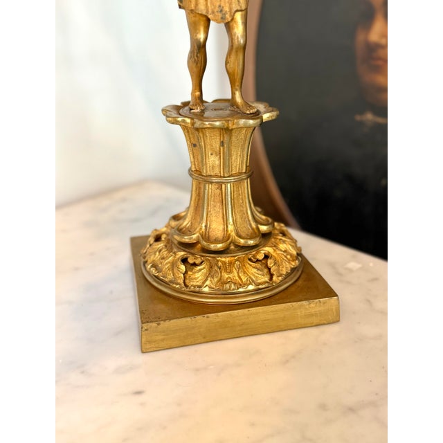 A striking matched pair of American gilt brass five-light figural candelabra by H.N. Hooper & Co. of Boston, dating to...