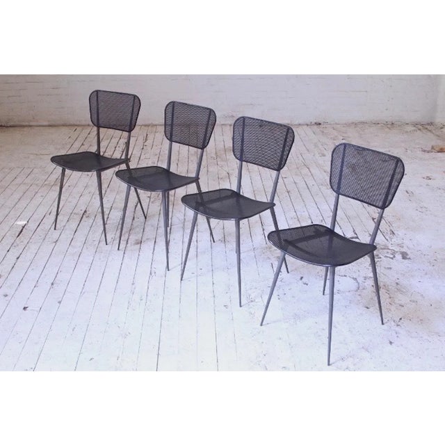 Striking set of four vintage dining chairs attributed to Mathieu Matégot in his trademark perforated and lacquered sheet...