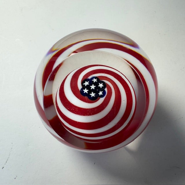Vintage GES Glass Eye Studio “Old Glory” paperweight, featuring a striking red, white, and blue swirl with a central...
