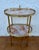 Elegant two-tier side table crafted in brass and onyx marble, featuring a refined oval silhouette and a light,...