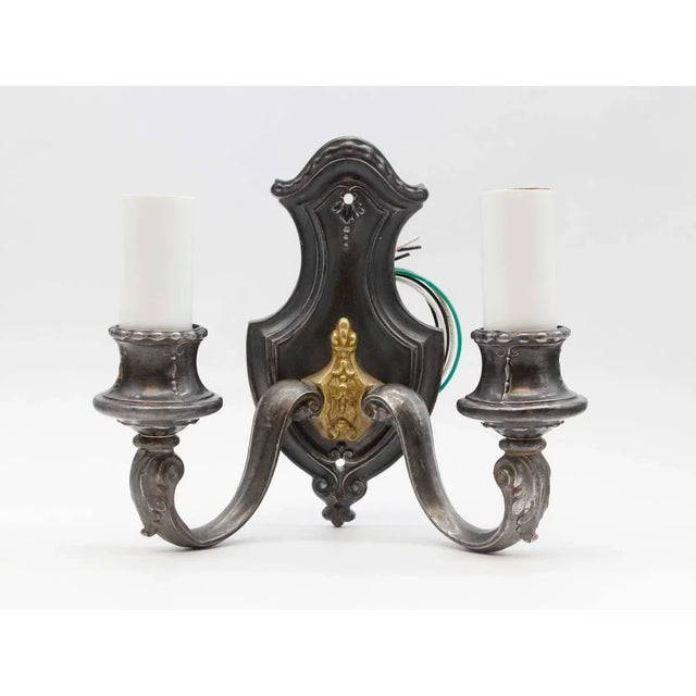These two arm sconces are wired to hold two Edison bulbs each. The finish is antique pewter over brass with a brass...