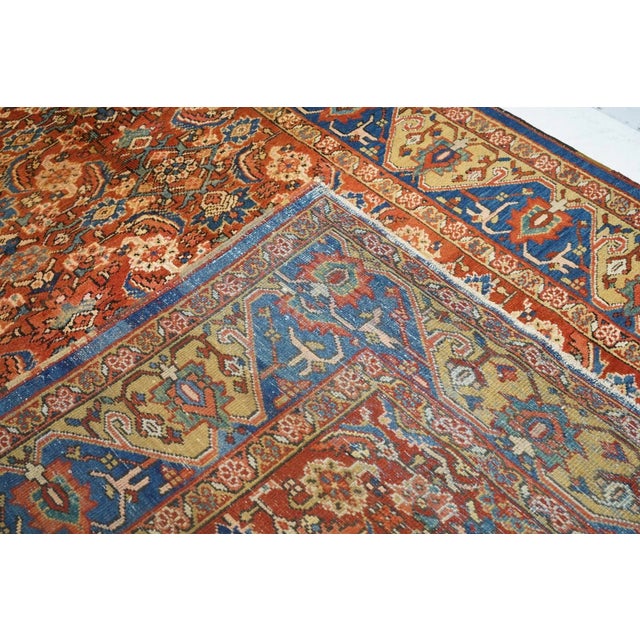 The red field uniformly displays an allover four column Herati design of palmettes, rosettes, curved leaves and open...