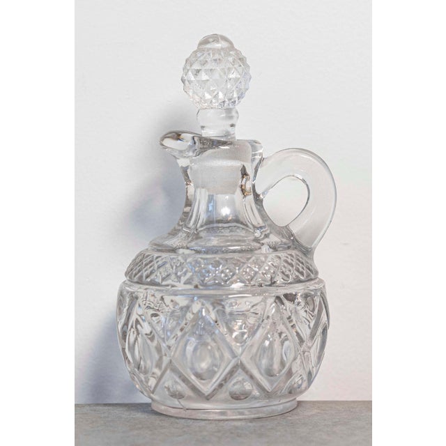 This exquisite 20th-century miniature cut glass olive oil pitcher is a charming and functional piece that showcases the...