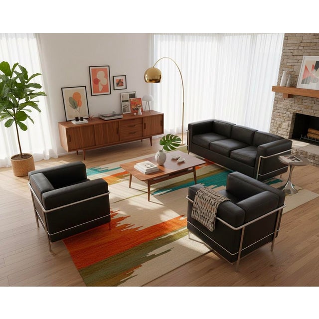 Matching set includes one three-seat sofa and two armchairs upholstered in black leather with polished chrome tubular...