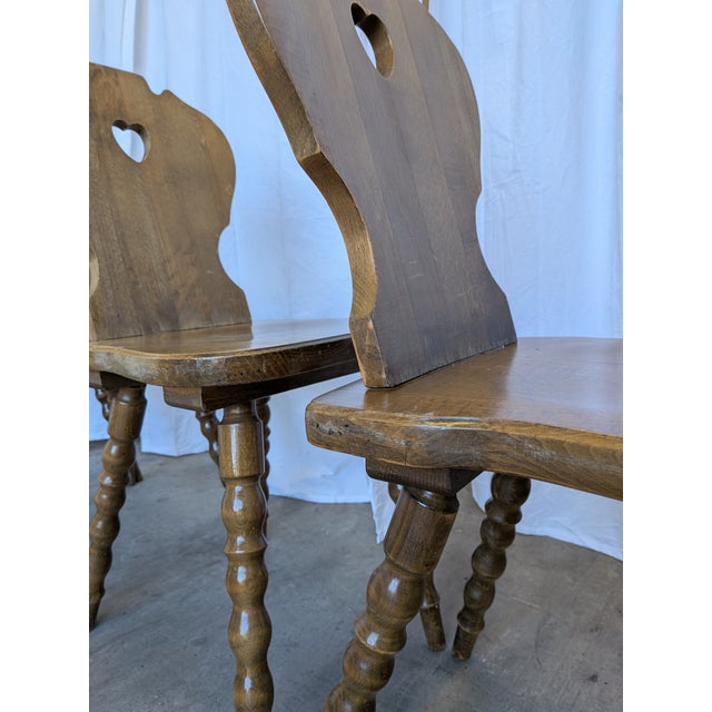 Set of 8 vintage wooden dining chairs in Tyrolean style. The chairs feature solid wooden construction with bobbin-turned...