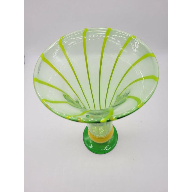 Formed in the graceful shape of a blooming tulip, the vase features a flaring, petal-like rim that seems to capture the...