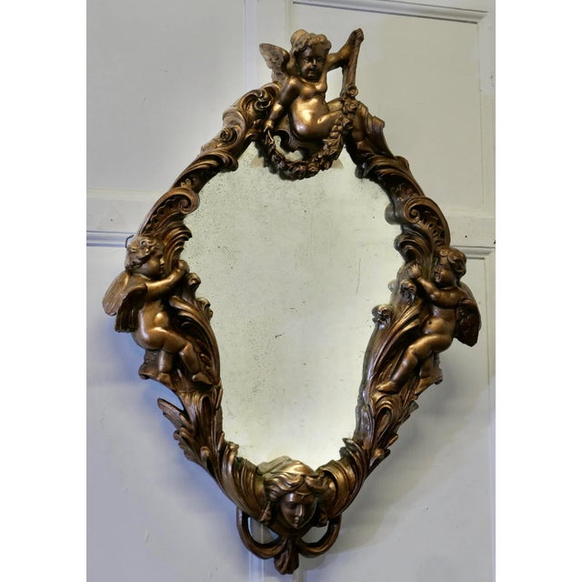 18th Century Italian Gilded Baroque Mirror A Rare find, this stunning piece is decorated with winged cherubs and the face...