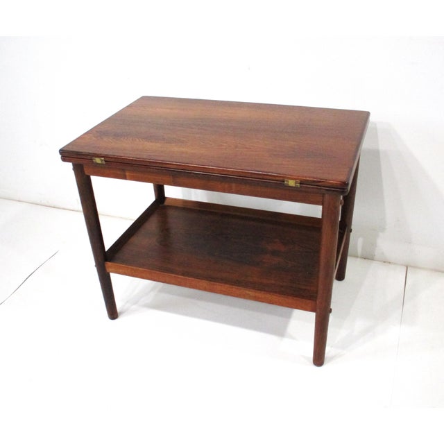 A very crafted and unique Brazilian rosewood swiveling top end/ side table that folds into a bigger table that can be used...
