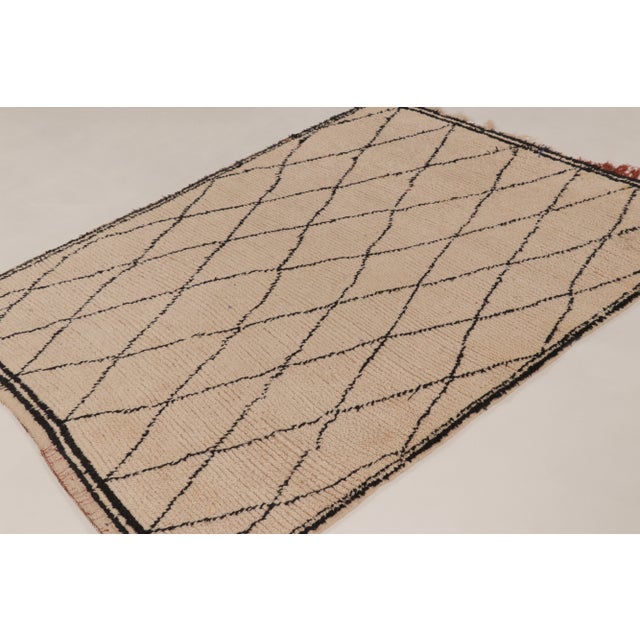 Handknotted in wool and originating from Morocco circa 1950-1960, this 5x6 vintage Moroccan tribal rug is an exciting new...