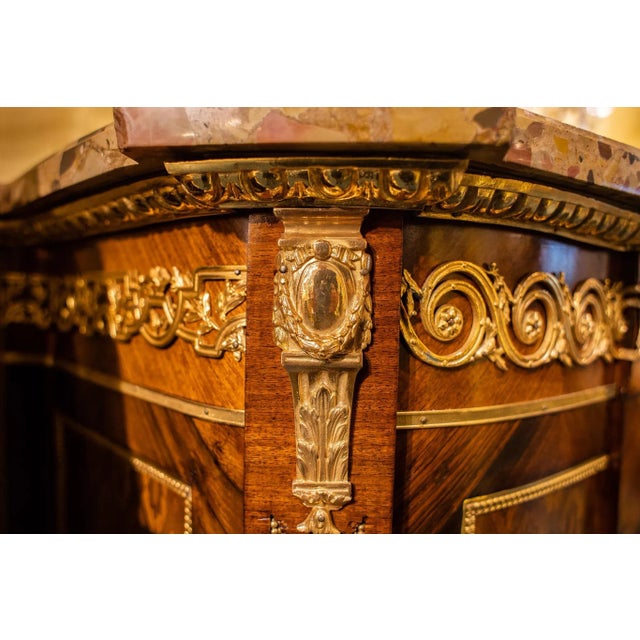 A fine very quality tall French Louis XVI style kingwood, marquetry inlaid bronze-mounted marble-top commode. The front...