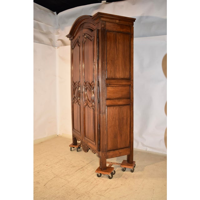 18th century walnut armoire from France. The arched crown is wonderfully molded and sits atop a grand case. The doors have...