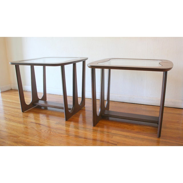 This is a pair of mid century modern Brasilia style side end tables made by Bassett. The tables have solid wood Brasilia...
