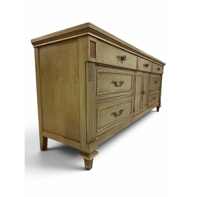 Elevate your space with this magnificent vintage statement triple dresser credenza produced by the renowned White Fine...
