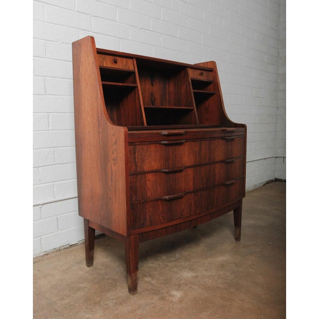 This exceptional Danish Modern secretary desk features striking bookmatched rosewood grain and sculptural drawer pulls,...