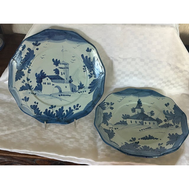 This pair of plates are suitable for wall hangings. They are hand painted in blue and white and depict country buildings....