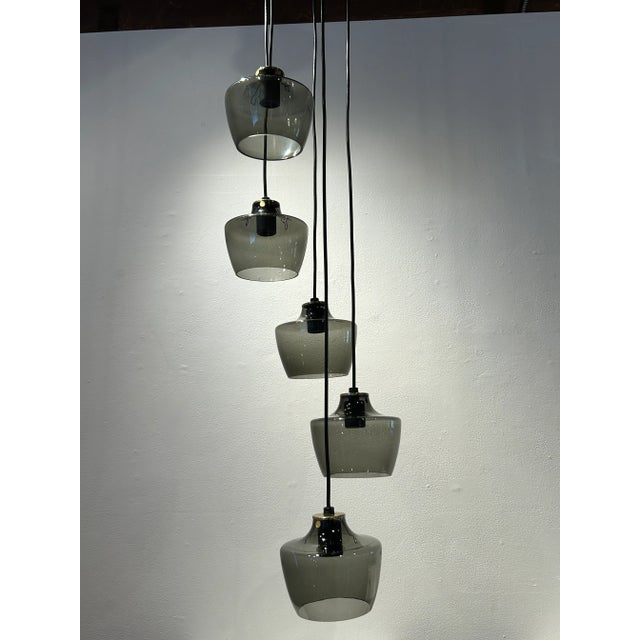 Brass chandelier manufactured around 1970. The glass shades have "made in Germany" tags. The cords are adjustable, so the...