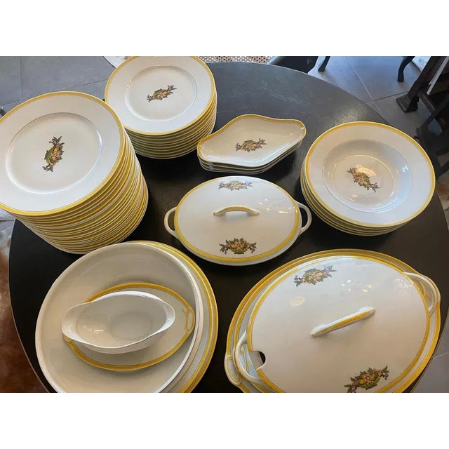 Magnificent Art Deco table service in Limoges porcelain with a yellow border and a floral decoration in the center. 49...