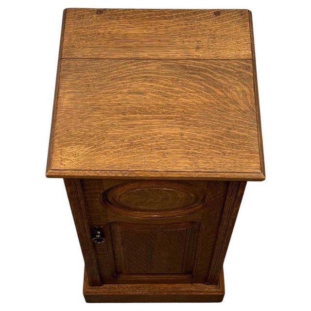 A charming English oak bedside pot cupboard dating from the 20th century, beautifully constructed and displaying the...