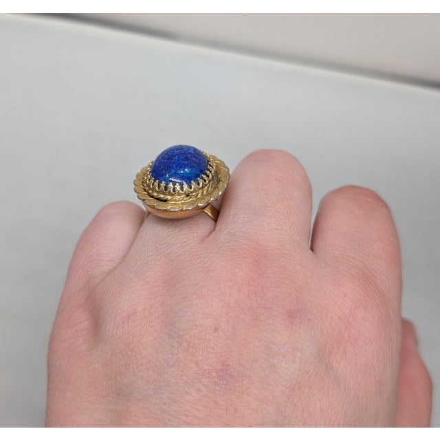 1968 goldtone prong set cabochon speckled faux-lapis "poison" adjustable ring with hidden compartment. Marked "NAPIER©" on...