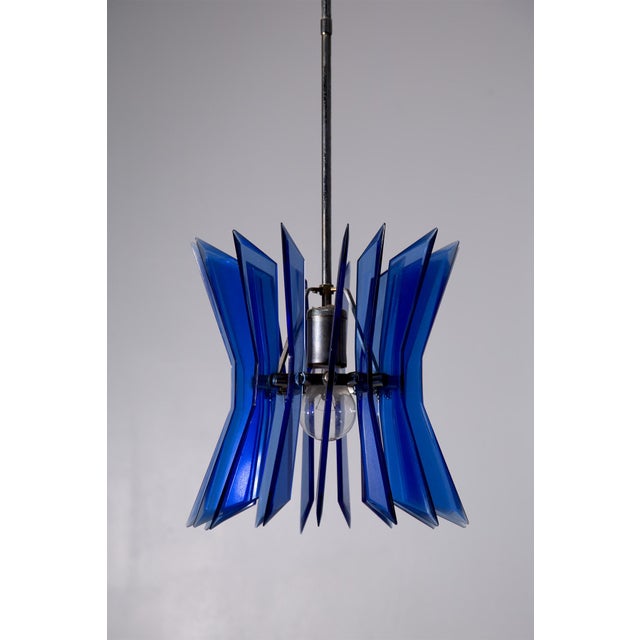 This blue glass pendant lamp, dating back to the 1970s, is a testament to the boldness and sophistication of Italian...