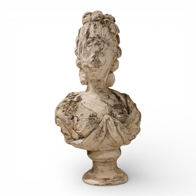 An elegant 19th-century cast stone bust depicting a classical female figure, beautifully modeled with soft, idealized...