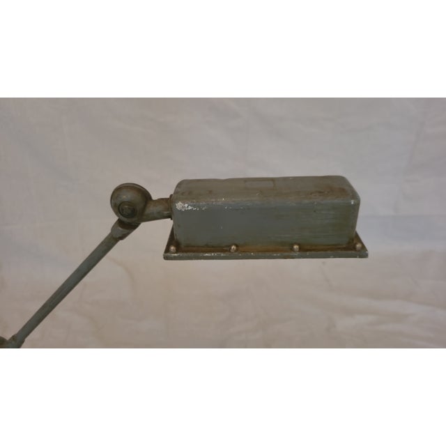 This is a very unique, vintage factory desk lamp, painted light grey with a wood block base and braided fabric cord.