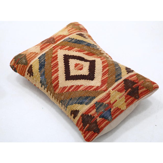 A one-of-a-kind handwoven Afghan wool kilim lumbar pillow featuring concentric diamond medallion. Cut and sewn by hand...