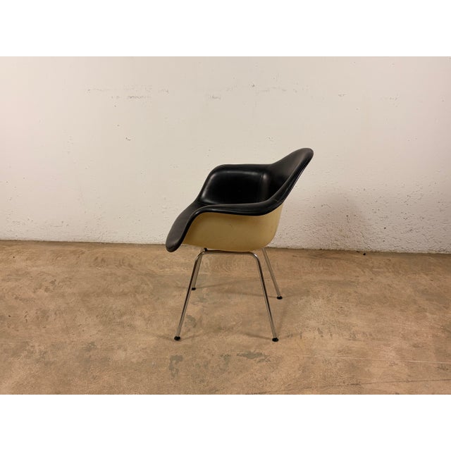 Iconic DAX armchair with a cream/white fiberglass seat shell upholstered in black leather (vinyl/padding). The chair...